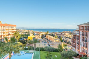 A coastal residential area with a swimming pool, multiple-story buildings, and a view of the sea. - Apartamento Liria (La Mata) (Torrevieja)