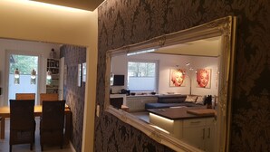 A room with a dining area, a sofa, a TV, and artwork on the wall. - Hexenglück Stylish apartment in the center of Hahnenklee (Goslar)