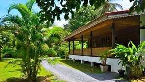 A covered outdoor area with a gravel path leading to a building with a wooden roof and white walls. - Handcrafted Lodge short walk from Mae Nam beach (Koh Samui)