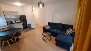 Un appartement moderne comprenant une cuisine, un coin repas et un salon.