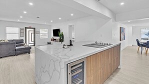 Una cucina moderna con isola in marmo, mobili in legno ed elettrodomestici integrati.