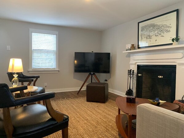 A living room with a flat-screen TV, a fireplace, and a framed picture on the wall.