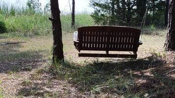 Een houten bankje in een natuurlijke omgeving, met een meer op de achtergrond.