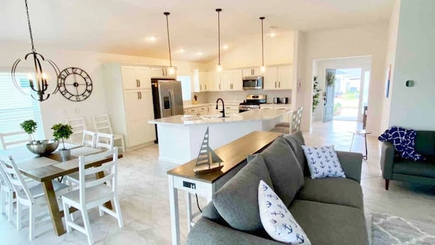 A modern kitchen with white cabinets, a central island, and pendant lighting. - The Villages 3 bed/3 Kings, Private, Coastal decor, 1 min to Rec cntr & Pickleba (The Villages)