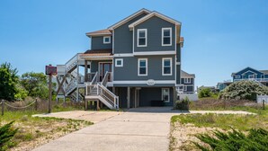A two-story building with a covered walkway and a basketball hoop. - Oceanside, Lovely, New home! Sat-Sat (Corolla)