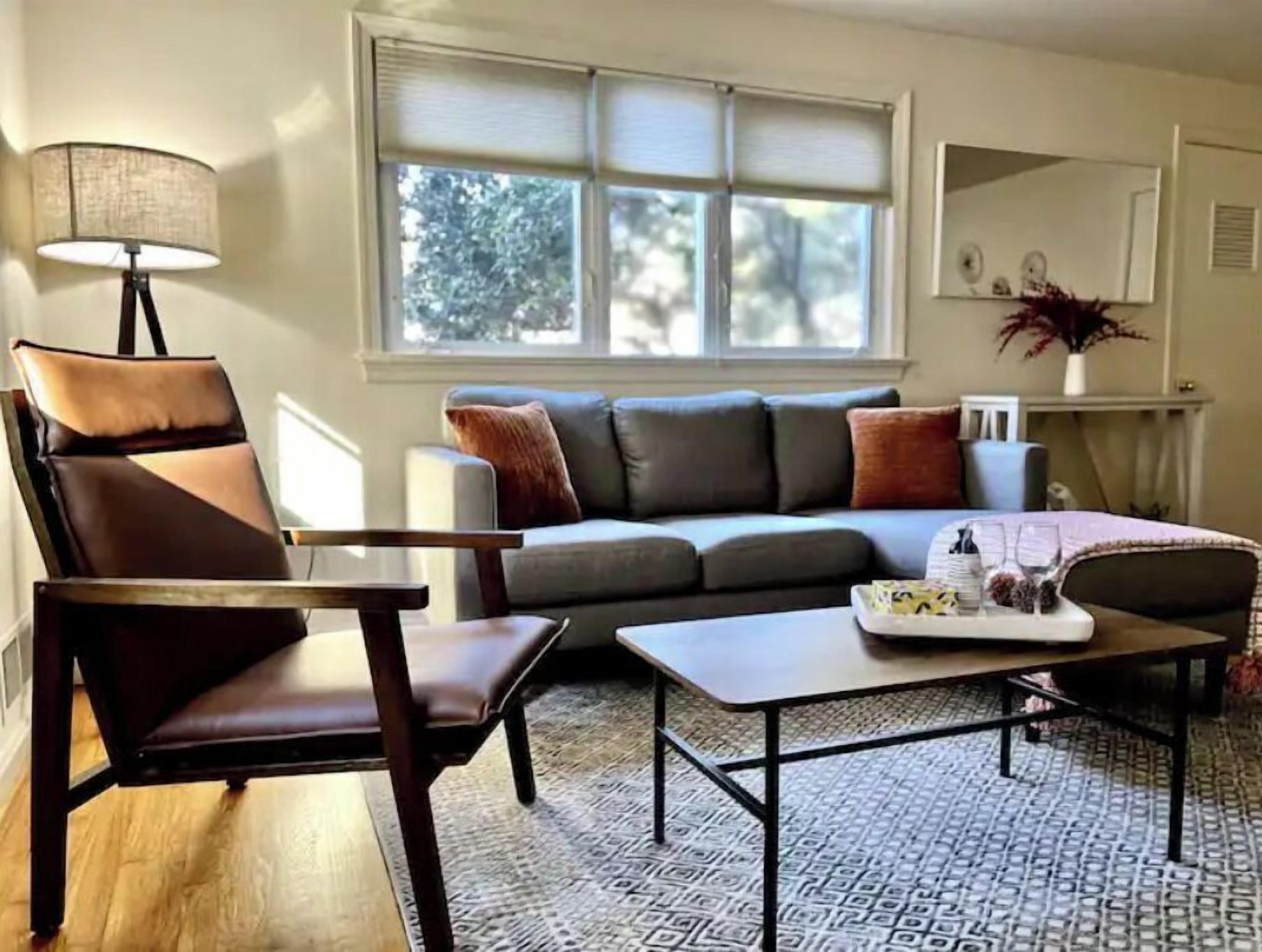 A living room with a sofa, a chair, a coffee table, and a lamp.