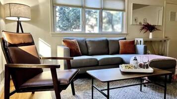 A living room with a sofa, a chair, a coffee table, and a lamp.