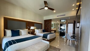 A hotel room with two beds, a bench, a ceiling fan, a bathroom, and a TV. - 9666llkhll (San Jose del Cabo)