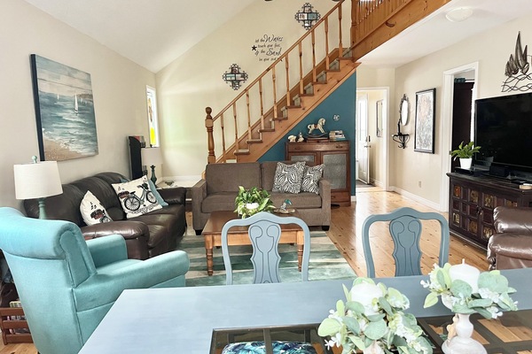 Open concept great room with lots of seating, large dining table, and sofa bed