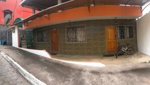 Un edificio residencial con dos puertas de madera, una bicicleta estacionada afuera y un camino de entrada pavimentado.