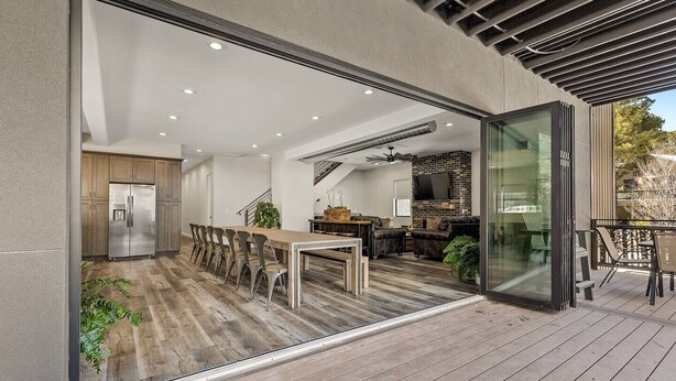 A modern kitchen with a stainless steel refrigerator, wooden dining table, and chairs. - "The Spruce"-Gathering Tree is your Ultimate Family Reunion Spot (Flagstaff)