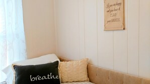 Une chambre bien rangée, avec un lit, des oreillers et une citation inspirante sur le mur.