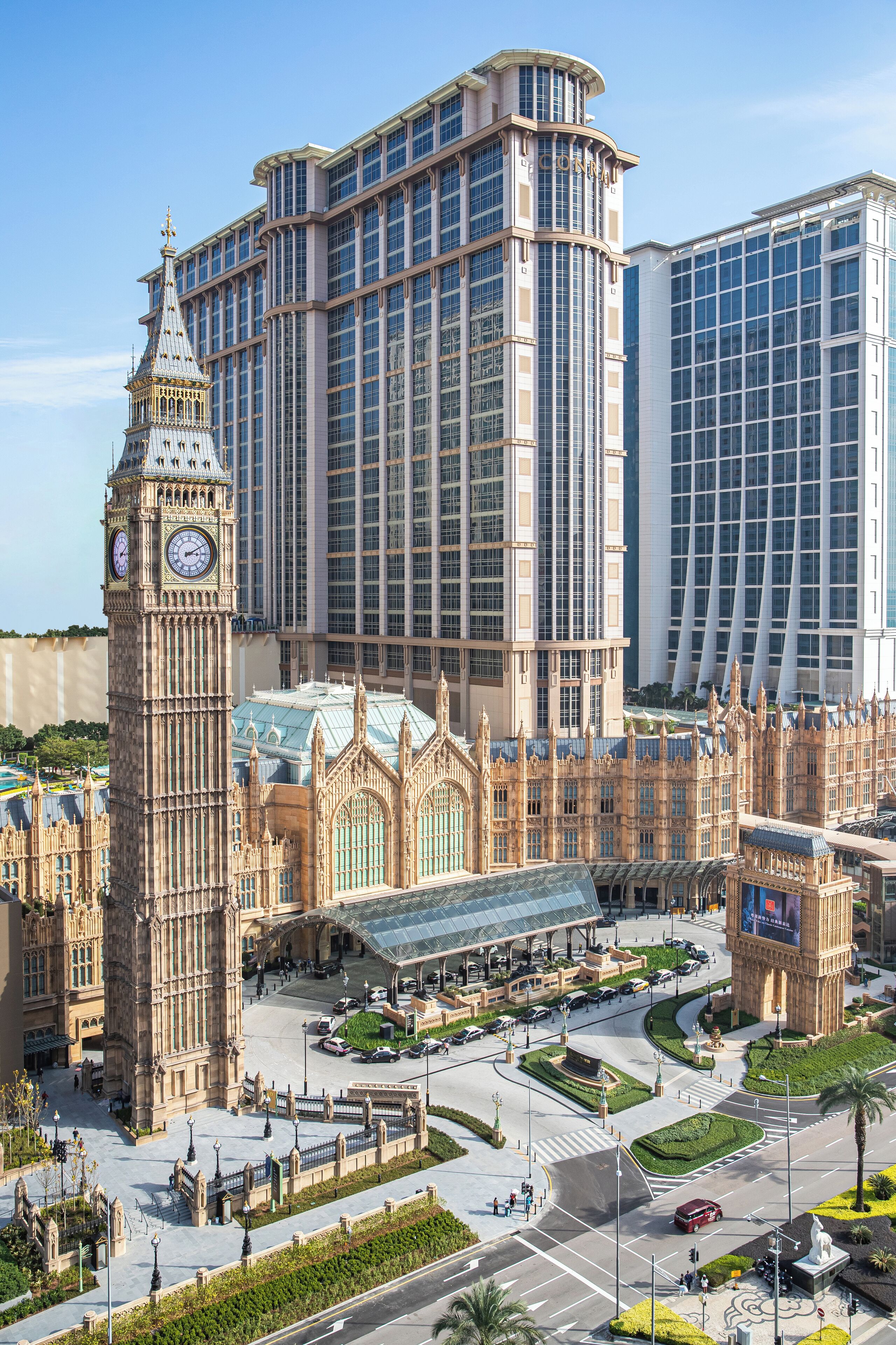 Un edificio grande con una torre de reloj, rodeado de modernos rascacielos.