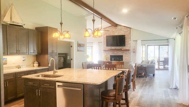 A spacious kitchen with a large island, built-in appliances, and pendant lighting. - Waterfront Retreat (New Bern)