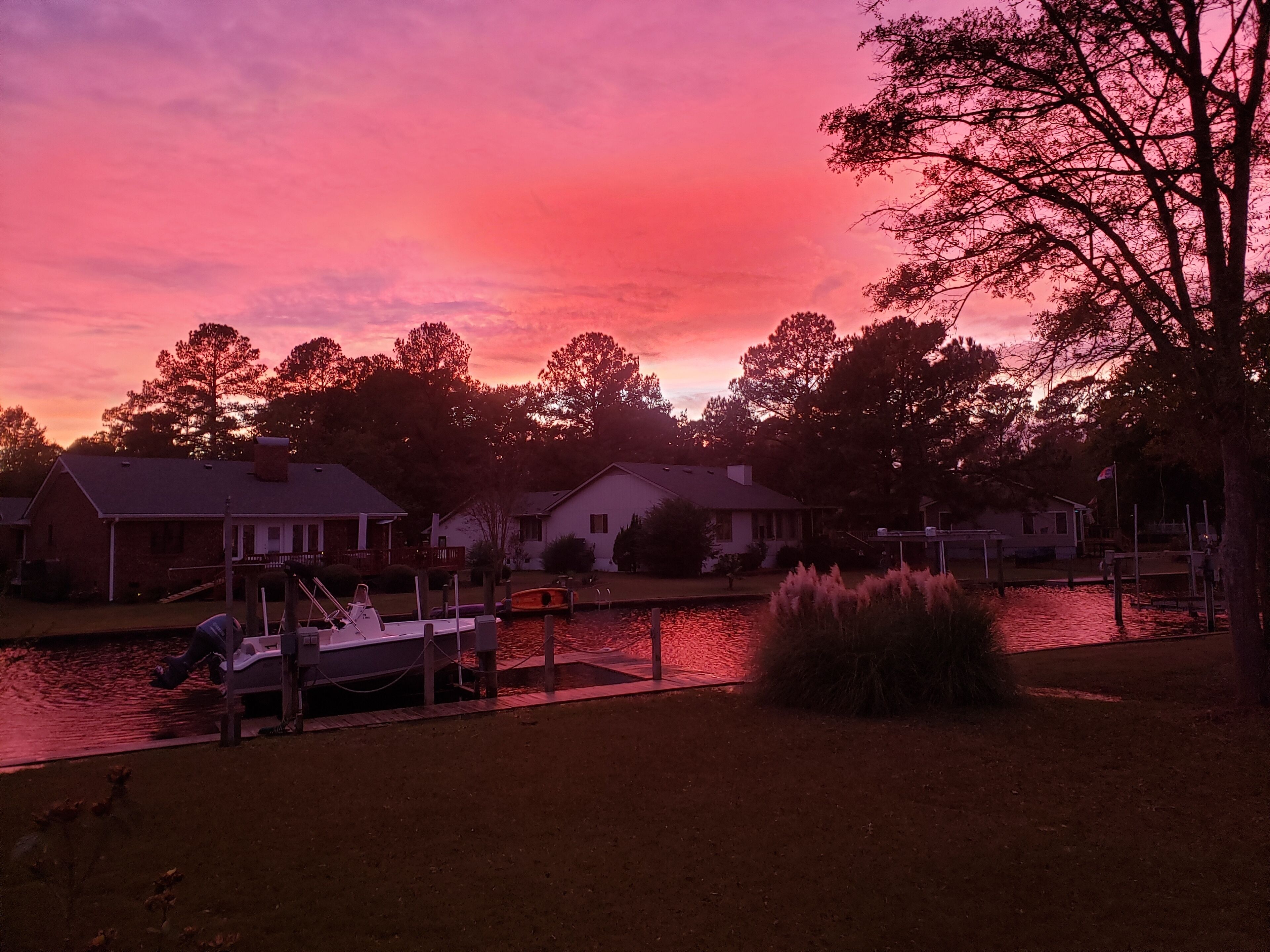 A waterfront property with houses, a dock, and a boat.