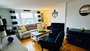 A living room with a sofa, armchair, coffee table, and a small side table.