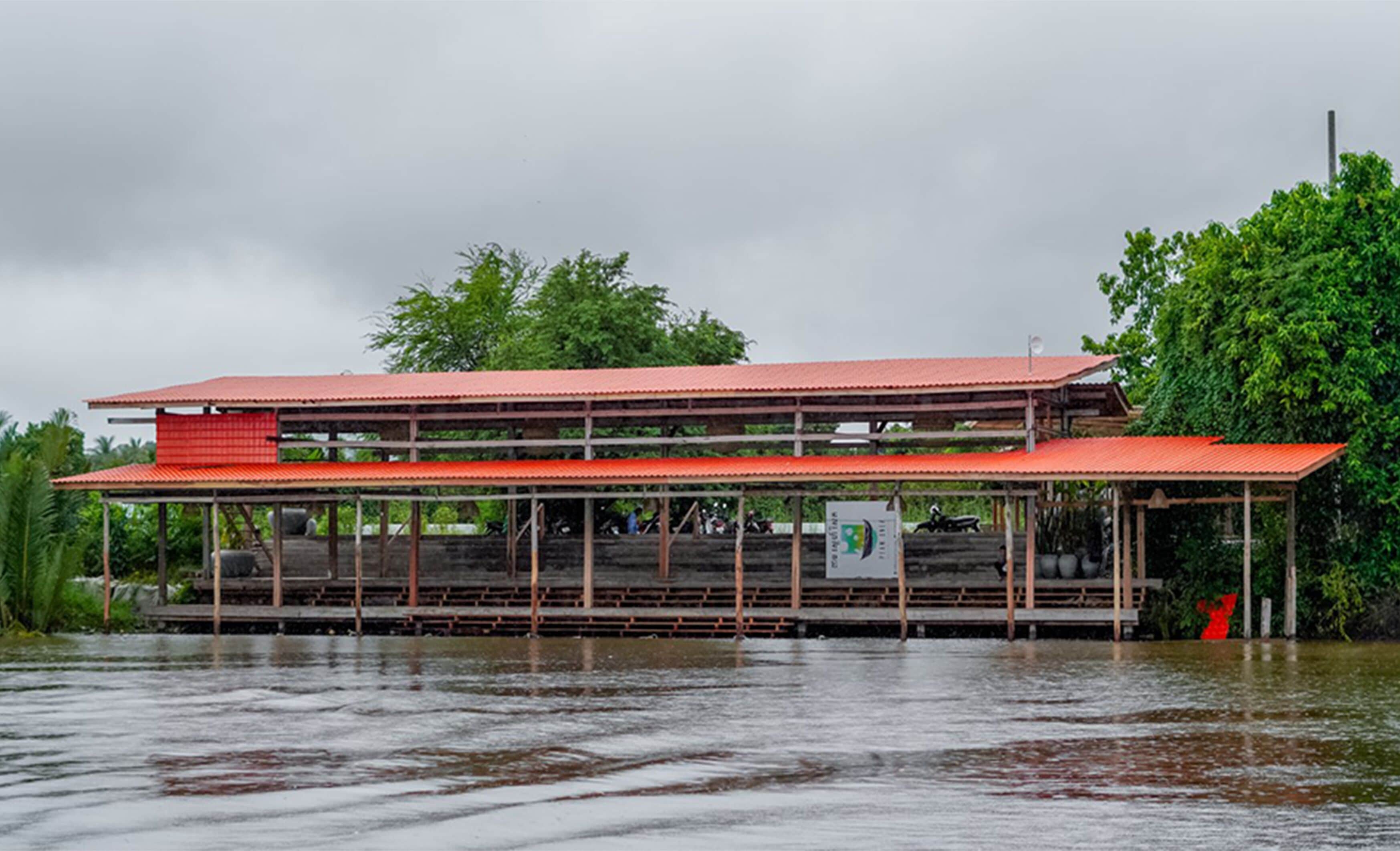 A two-story building with a red roof and a covered walkway.