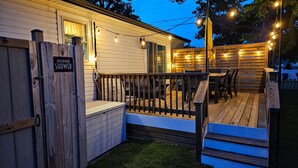 Eine Holzterrasse mit Sitzgelegenheiten und Lichterketten.