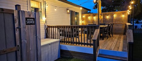 A wooden deck with outdoor seating and string lights.