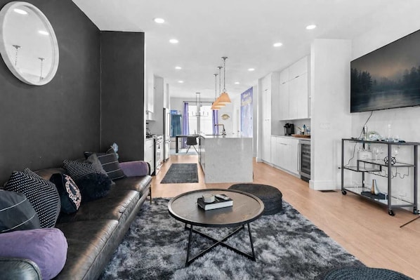 A modern living room with a sofa, coffee table, and a painting on the wall.