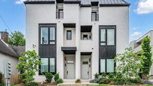 A modern two-story house with a front entrance, a small front yard, and a visible driveway. - Group-Friendly 2 Nashville Homes • Sleeps 15 (Nashville)