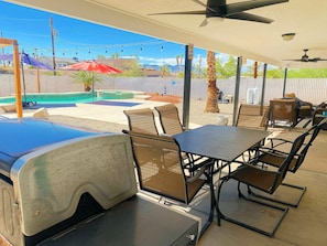 A covered outdoor patio with a grill, seating, and a pool. - COZY HAVASU OASIS just minutes from the lake And all shopping! (Lake Havasu City)