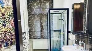 Ein modernes Badezimmer mit Duschkabine aus Glas, einem weißen Waschbecken und einer Toilette.