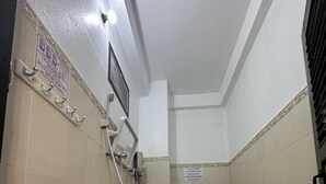 A small, tiled bathroom with a sink, toilet, and handrails. - VangVieng Santara Hotel (Vang Vieng)