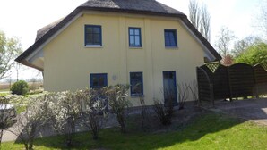 Kaksikerroksinen talo, jossa on harjakatto, pääovi ja useita ikkunoita.