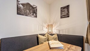 Ein Zimmer mit einem Holztisch, einer Couch und zwei gerahmten Bildern an der Wand.