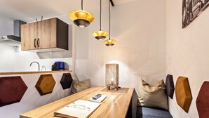 A modern kitchen with wooden cabinets, a built-in stove, and pendant lighting. - Apartment 'Bergwelt A2' with Mountain View, Balcony and Wi-Fi (Niederau)