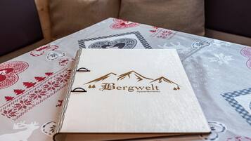 Een boek met de titel 'Bergwelt Apartments' op een tafel met een tafelkleed met dessin.