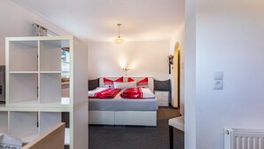 Ein Schlafzimmer mit Bett, Nachttischen, einem Kleiderschrank und einer Heizung.