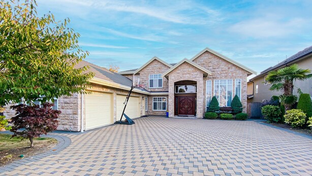 A residential house with a brick driveway, a garage, and a front yard with a tree and shrubs. - Cozy King Sized Private Entrance Suite 15 min from YVR and self check in (Richmond)