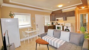 A compact living space with a kitchenette, a dining area, and a seating area with a sofa and a small table. - Cozy King Sized Private Entrance Suite 15 min from YVR and self check in (Richmond)