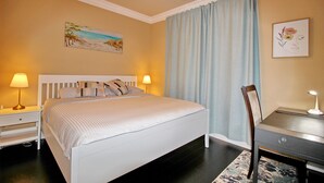 A neatly arranged bedroom with a bed, bedside tables, a desk, and a chair. - Cozy King Sized Private Entrance Suite 15 min from YVR and self check in (Richmond)