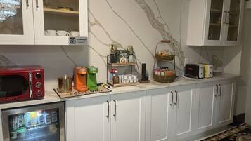A kitchen with white cabinets, a microwave, a coffee maker, and a toaster.