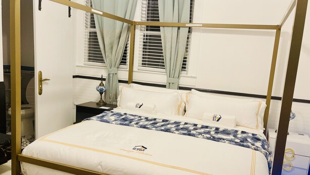 A four-poster bed with white bedding and a blue and white patterned throw. - Prestige Collection Boutique hotel (St. Petersburg)