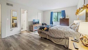 A bedroom with a bed, a dresser, a nightstand, a TV, and a window with curtains. - Two bedroom condo for rent! (Columbus)