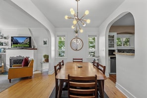 A dining area with a wooden table and chairs, a television, and a fireplace. - Boise-Westend-hot tub-Central location 4 bedrooms (Boise)