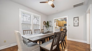 A dining area with a wooden table, chairs, and a ceiling fan. - 4 min walk to Town Square! 3bd 2bath cozy Historical home (Georgetown)