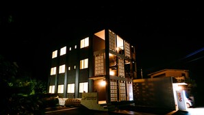 Een meerlaags gebouw met verlichte ramen en een duidelijke ingang.