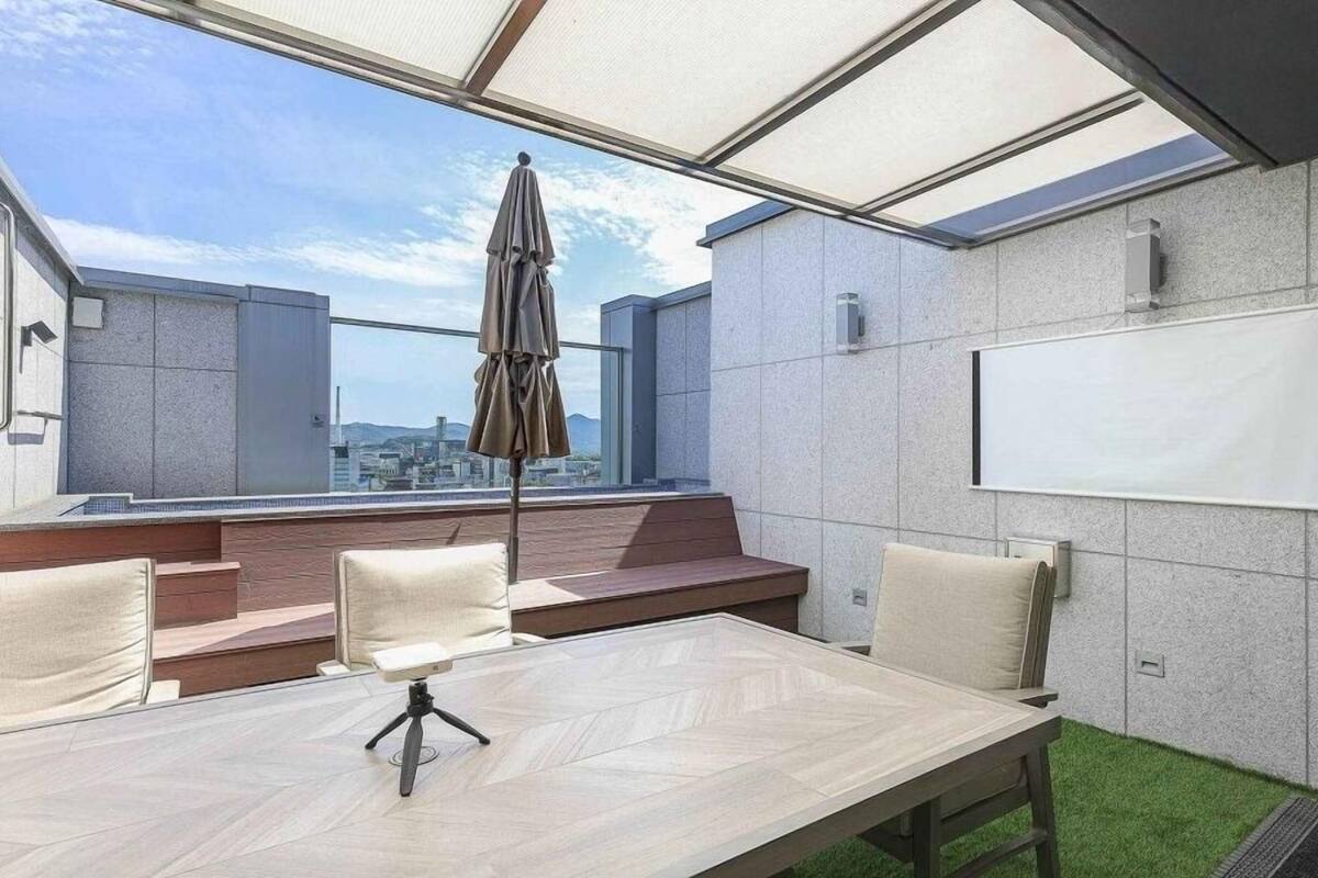 Une salle de conférence avec vue sur la ville, un écran de projection et une table entourée de chaises.