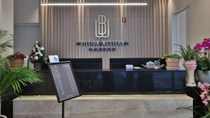Una recepción de diseño moderno, con un logotipo y el nombre 'Billion Western Hotel'.