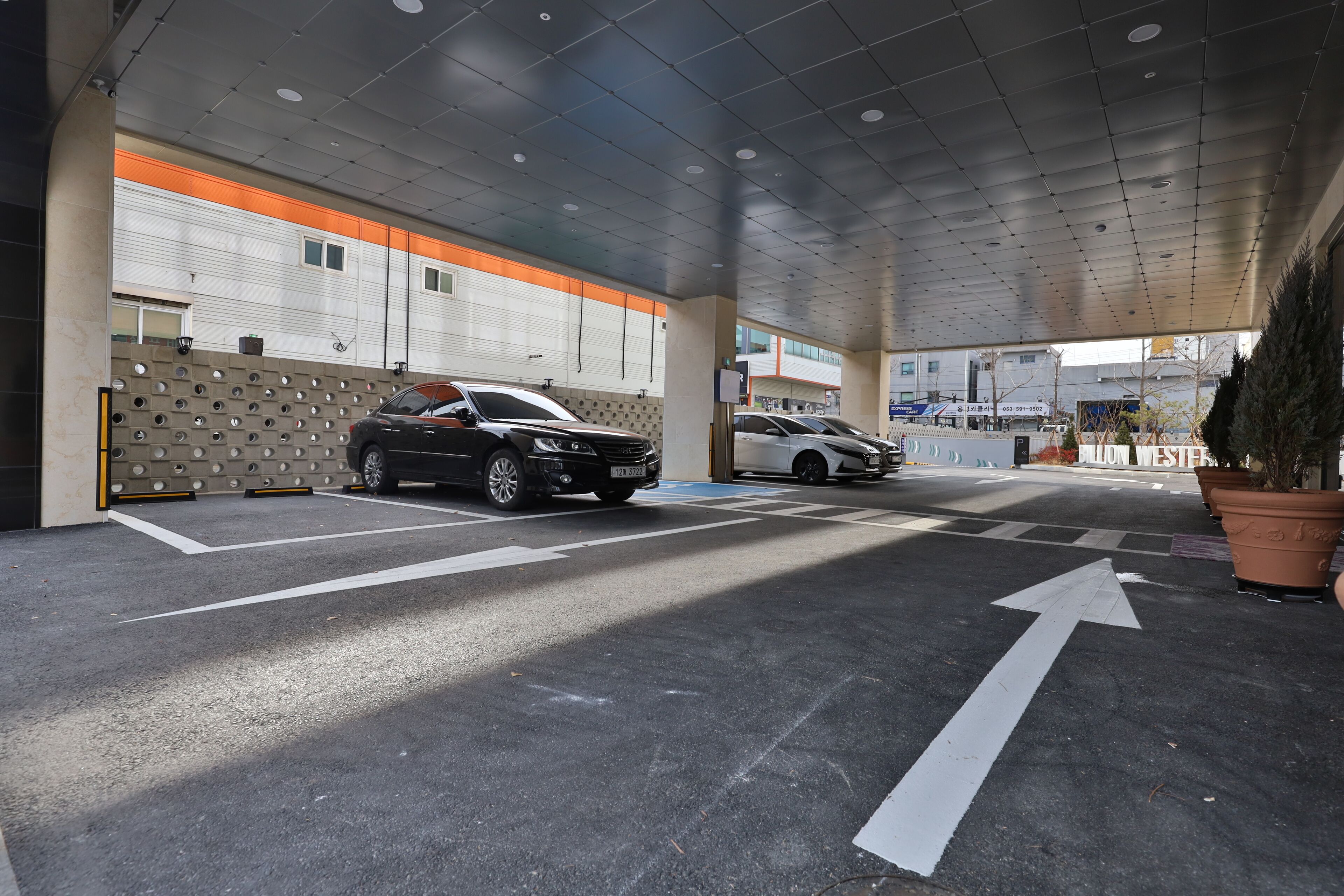 A parking garage with multiple levels, marked lanes, and directional arrows on the floor.