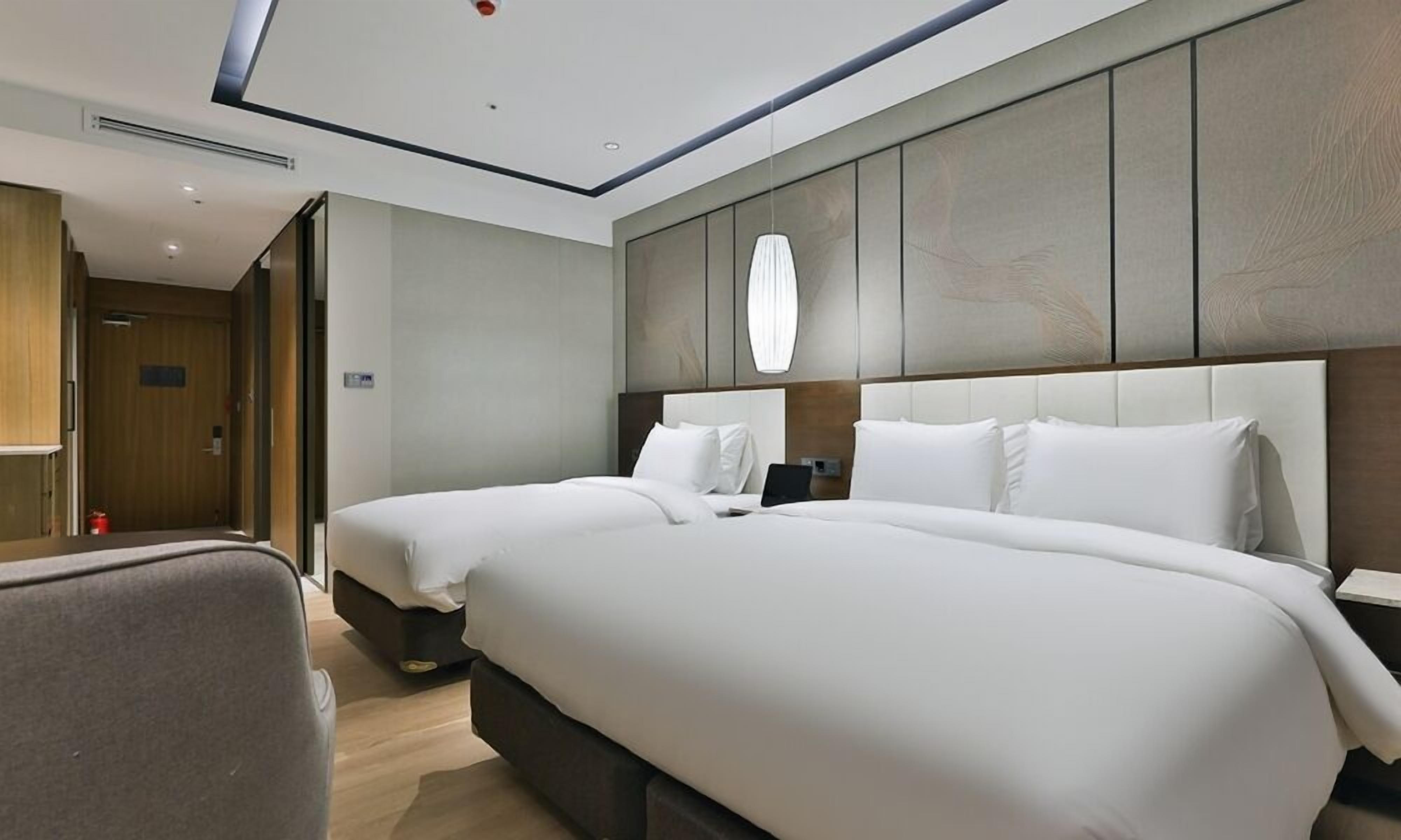 Una habitación de hotel con dos camas, un escritorio y una silla.