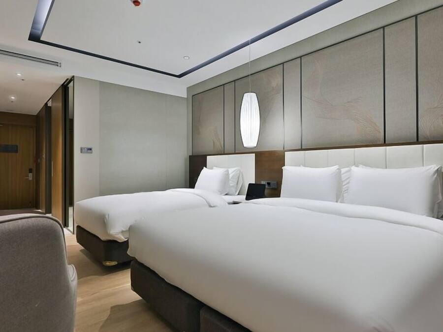 Una habitación de hotel con dos camas, un escritorio y una silla.
