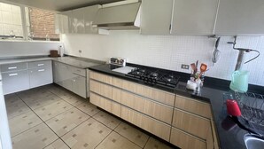 Una cucina moderna con piano cottura a gas, mobili in legno e lavello in acciaio inossidabile.