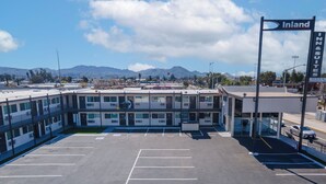 A parking lot with a building labeled "Inland Inn & Suites" in the background. -  Inland Inn & Suites (San Bernardino)