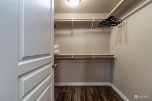 Spacious closet with a single hanging rod and black hangers.